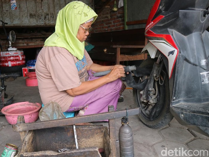 Mbah Kasminah (70) bekerja menambal ban di bengkelnya, Kudus, Selasa (4/5/2021).