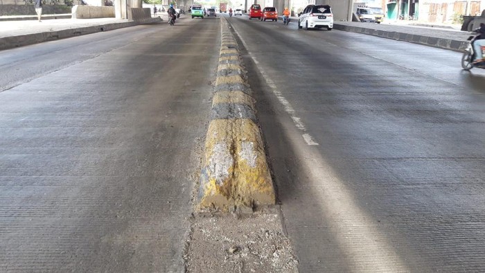 Pembatas jalan di Jl Raya Cilincing Raya di depan New Priok Common Gate usai sebulan dicat ulang.