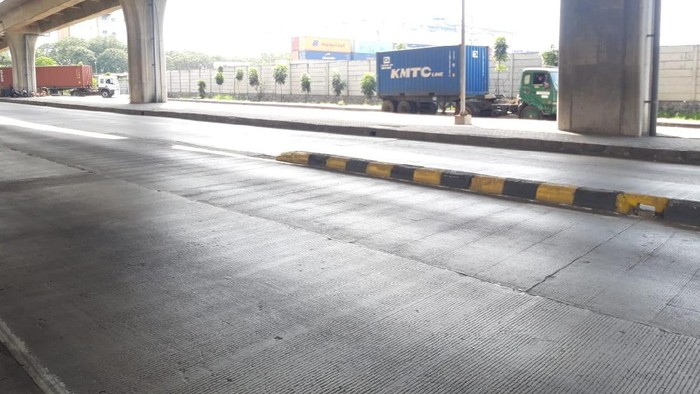 Pembatas jalan di Jl Raya Cilincing Raya di depan New Priok Common Gate usai sebulan dicat ulang.