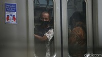 Mereka tampak antre menunggu giliran mengetap kartu uang elektronik untuk masuk area peron. Petugas keamanan stasiun terlihat mengatur antrean tersebut.