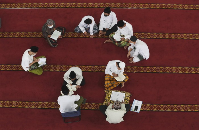 Students wear face masks to help curb the spread of the coronavirus as they read the Muslim holy book of the Quran at Attaqwa mosque in Bekasi, Indonesia, Tuesday, May 4, 2021. During Ramadan, the holiest month in Islamic calendar, Muslims refrain from eating, drinking, smoking and sex from dawn to dusk. (AP Photo/Achmad Ibrahim)