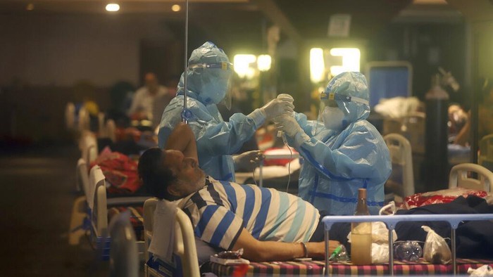 Virus Outbreak FILE - In this April 30, 2021, file photo, health workers attend to COVID-19 patients at a makeshift hospital in New Delhi, India. COVID-19 infections and deaths are mounting with alarming speed in India with no end in sight to the crisis. People are dying because of shortages of bottled oxygen and hospital beds or because they couldn’t get a COVID-19 test. (AP Photo/File)