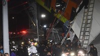 Rangkaian kereta yang sedang melaju di rel layang itu pun terjatuh ke bawah, menimpa mobil-mobil yang ada di ruas jalanan di bawah rel layang tersebut. Sejumlah mobil dilaporkan terkubur reruntuhan. AP Photo/Jose Ruiz  
