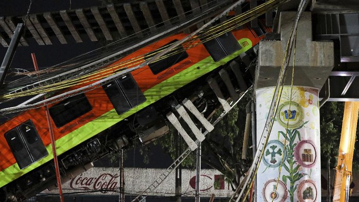 Waduh, Rel Layang di Meksiko Ambruk Saat Kereta Lewat Mexico City's subway cars lay at an angle after a section of Line 12 of the subway collapsed in Mexico City, Tuesday, May 4, 2021. The section passing over a road in southern Mexico City collapsed Monday night, dropping a subway train, trapping cars and causing at least 50 injuries, authorities said. (AP Photo/Marco Ugarte)