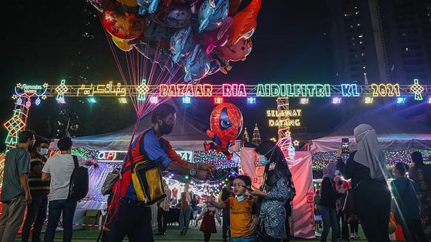 A man sells balloons to customers at a Ramadan bazaar in Kuala Lumpur, Malaysia. Ramadan bazaars in Malaysia offering various selections of clothing, food, and other religious items to Muslims who traditionally shop for new outfits to usher Eid al-Fitr, known as the 
