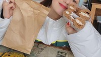 Tak hanya kue kering, berfoto dengan roti bagel juga ternyata membuat Somi sangat senang dan tersenyum lebar. Foto: Instagram@somsomi0309