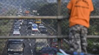 Seorang anak melihat kendaraan pemudik yang melintasi Tol Palimanan-Kanci.