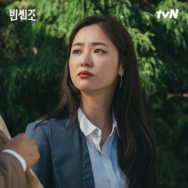 Setelan motif garis-garis menjadi salah satu office look andalan pekerja kantoran. Setelan bernuansa abu-abu dapat dipadukan dengan kemeja berwarna netral, seperti putih. Anting panjang pun menambah kesan feminin karakter Jeon Yeo Bin. Foto: dok. tvN