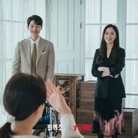 Sebuah adegan hangat dalam drama Korea Vincenzo memperlihatkan Jeon Yeo Bin menemani Song Joong Ki dan ‘ibunya’ berfoto. Tampilannya dapat ditiru sebagai office look dengan memadukan setelan hitam dan rok bermotif dengan detail pleats. Foto: dok. tvN