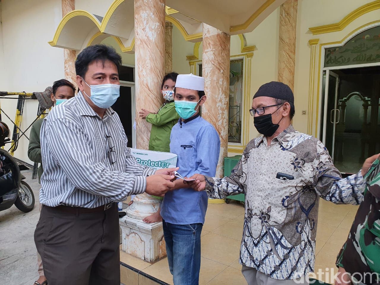 Kini, Roni memasangkan masker ke Nawir sebagai simbol keduanya telah berdamai.