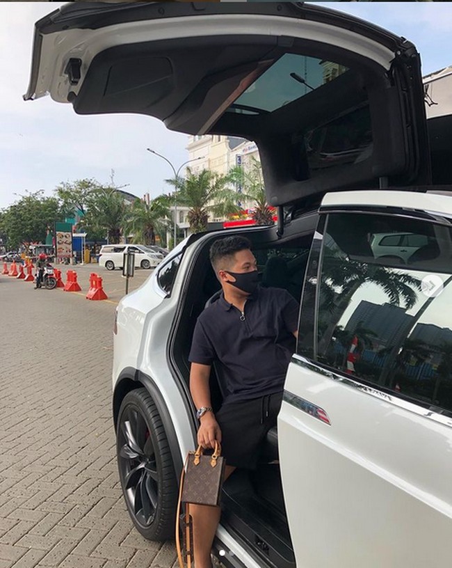 Inilah Setya Nugraha sempat viral karena konten yang memperlihatkan dia memesan ojek online hanya untuk mengelilingi rumahnya yang luas. Di Instagram, ia kerap memamerkan OOTD dengan barang-barang branded. Seperti ketika berpose di mobil Tesla ini, ia menggunakan tas mini Louis Vuitton. (Foto: Instagram/@setyanugraha21)