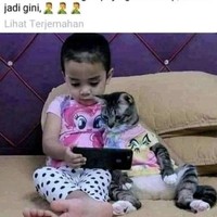 Namun sungguh tak diduga, bukannya berhenti bermain HP, sang anak justru tetap bermain HP bersama si kucing. Foto-foto menggemaskan sang anak dengan kucing peliharaannya itu pun banyak beredar di internet dan disukai oleh para warganet. Foto: Facebook/Dunia Meong