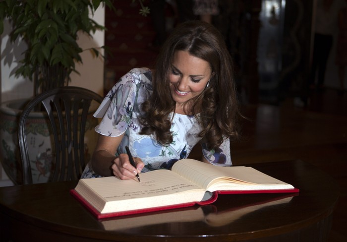 Kate Middleton SINGAPORE - SEPTEMBER 12: Catherine, Duchess of Cambridge signs the visitors book as she and her husband, Prince William, Duke of Cambridge (not pitured) visit the British High Commissioners residence, Eden Hall, on day 2 of the Diamond Jubilee Tour of the Far East on September 12, 2012 in Singapore. The Duke and Duchess of Cambridge are on a Diamond Jubilee Tour of the Far East taking in Singapore, Malaysia, the Solomon Islands and the tiny Pacific Island of Tuvalu. (Photo by Ian Vogler - Pool/Getty Images)