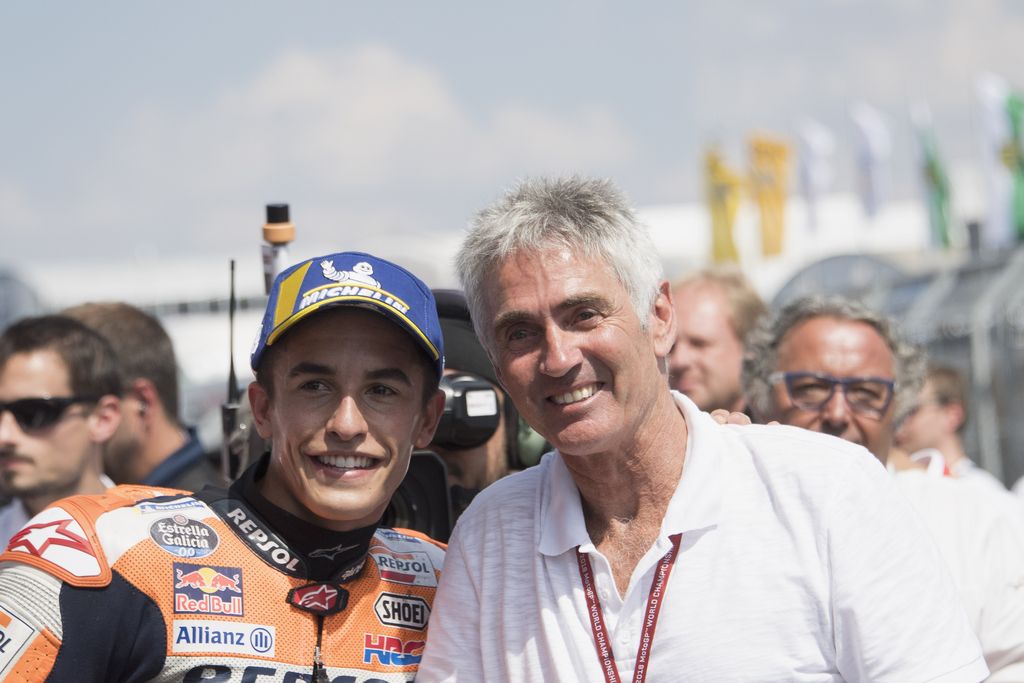 HOHENSTEIN-ERNSTTHAL, GERMANY - JULY 15:  Marc Marquez of Spain and Repsol Honda Team celebrates with Michael Doohan of Australia (R) under the podium at the end of the MotoGP race during the MotoGp of Germany - Race at Sachsenring Circuit on July 15, 2018 in Hohenstein-Ernstthal, Germany.  (Photo by Mirco Lazzari gp/Getty Images)