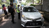 Petugas memberhentikan kendaraan plat nomor luar kota Solo.