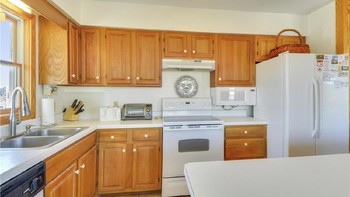 Dapur sederhana memiliki meja laminasi putih dan ubin krem. Foto: dok. TruPlace Premium Property Visual