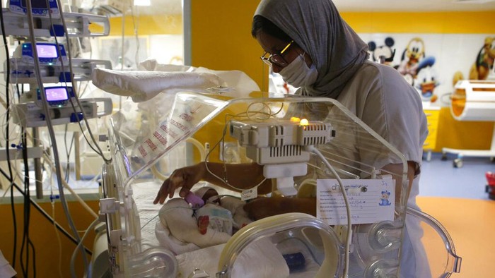 Surgeons Doctor Yazid, left, listens to the clinic's director Youssef Alaoui as they speak to the medias on the conditions of childbirth at the maternity ward of the private clinic of Ain Borja in Casablanca, Morocco, Wednesday, May 5, 2021. A Malian woman gave birth to nine babies after expecting only seven, the Ministry of Health of Mali said on Wednesday. Halima Cissé, 25, gave birth by caesarean section Tuesday in Morocco after being sent there for special care, the ministry said. (AP Photo/Abdeljalil Bounhar)