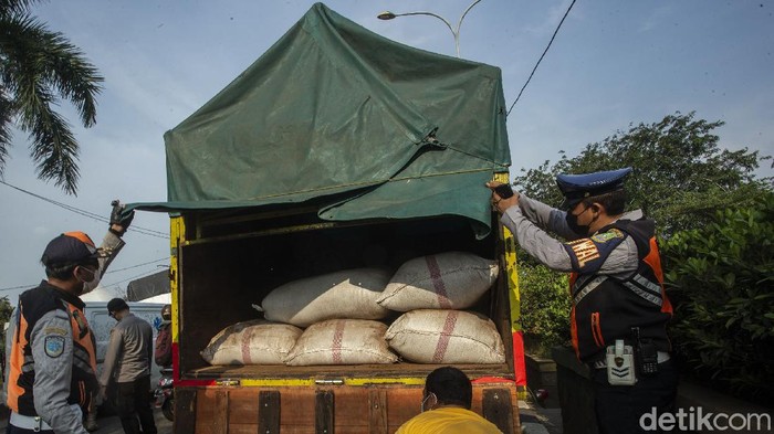 Petugas Satpol PP menurunkan penumpang truk di Kedungwaringin, Kabupaten Bekasi, Jumat (7/4/2021).