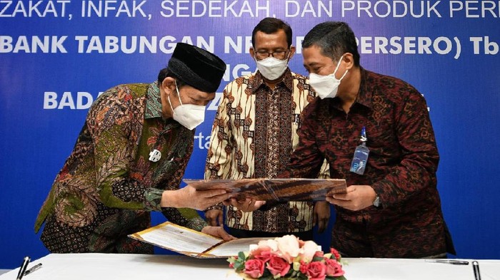 Kini Bayar Zakat jadi Semakin Mudah Direktur Utama PT Bank Tabungan Negara (Persero) Tbk. Haru Koesmahargyo (tengah) menyaksikan Nota Kesepahaman yang ditandatangani Direktur Consumer and Commercial Lending Bank BTN Hirwandi Gafar (kanan) dan Ketua Badan Amil Zakat Nasional (BAZNAS) Noor Achmad pada acara Penandatanganan Nota Kesepahaman antara Bank BTN dan Baznas di Jakarta, Jumat (7/5). BTN Syariah melakukan sinergi dengan BAZNAS untuk mengembangkan ekosistem layanan zakat, infak, dan sedekah sehingga pembayarannya menjadi lebih mudah. Selain menawarkan kemudahan pembayaran zakat, infak, dan sedekah, BTN Syariah juga menawarkan produk dan layanan perbankan lainnya untuk dapat mengoptimalkan kinerja BAZNAS. Bank BTN juga memberikan fasilitas pembiayaan termasuk KPR Syariah bagi para pengurus BAZNAS sehingga dapat memiliki hunian sendiri.