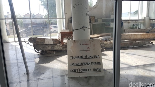 Terdapat papan yang bertuliskan JANGAN LUPAKAN TSUNAMI yang disanderkan pada salah satu tiang masjid. Terdapat papan yang bertuliskan JANGAN LUPAKAN TSUNAMI yang disanderkan pada salah satu tiang masjid.