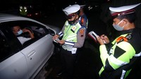 Personel kepolisian memeriksa surat kendaraan dan KTP saat penyekatan pemudik di jalur Pantura, Tegal, Kamis (6/5/2021).
