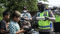 Petugas sekaligus memberikan masker kepada pengemudi yang tidak menggunakan masker.