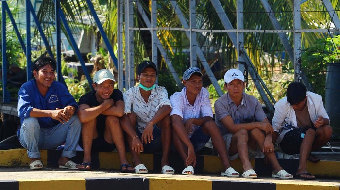 KAPAL VIETNAM PEMBURU TERIPANG DITANGKAP Sejumlah awak kapal berkewarganegaraan Vietnam duduk di dermaga Stasiun Pengawasan Sumber Daya Kelautan dan Perikanan (PSDKP) Pontianak di Kabupaten Kubu Raya, Kalimantan Barat, Sabtu (8/5/2021). Kapal Pengawas Perikanan Hiu Macan 01 Kementerian Kelautan dan Perikanan menangkap dua kapal berbendera Vietnam yang menggunakan alat penangkap trawl beserta sepuluh awak kapal yang sedang berburu teripang secara ilegal di Laut Natuna Utara pada Kamis (6/5/2021), dan selanjutnya digiring ke Stasiun PSDKP Pontianak untuk proses hukum lebih lanjut. ANTARA FOTO/Jessica Helena Wuysang/aww.