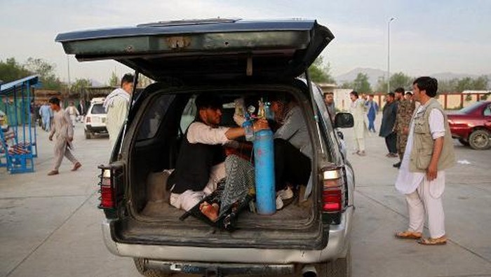 An injured man is being brought in a car to a hospital following a blast outside a school in the west Kabul district of Dasht-e-Barchi on May 8, 2021, that killed at least 25 people and wounded scores more including students, officials said. (Photo by ZAKERIA HASHIMI / AFP)