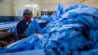 Seorang pekerja wanita tengah menyortir perlengkapan perlindungan diri (APD) di dalam fasilitas produksi APD Sipra Surgi-Med di kawasan Bengaluru, India, Sabtu (8/5/2021) waktu setempat.