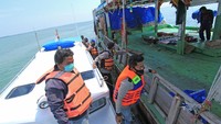 Personel Polair Polres Indramayu memeriksa kapal nelayan saat melakukan penyekatan jalur laut di perairan Indramayu, Jawa Barat, Minggu (9/5/2021).  