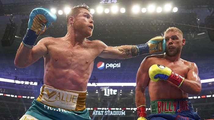 Canelo Alvarez, left, connects against Billy Joe Saunders during a unified super middleweight world championship boxing match, Saturday, May 8, 2021, in Arlington, Texas. (AP Photo/Jeffrey McWhorter)