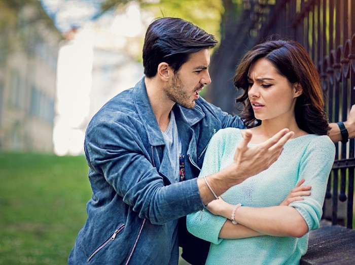 1129638655 Jealous suspicious mad wife arguing with obsessed husband holding phone texting cheating on cellphone, distrustful girlfriend annoyed with boyfriend mobile addiction, distrust social media dependence
