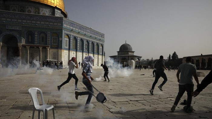 Bentrokan Palestina-Israel di Masjid Al-Aqsa Kembali Pecah Palestinians clash with Israeli security forces at the Al Aqsa Mosque compound in Jerusalem's Old City Monday, May 10, 2021. Israeli police clashed with Palestinian protesters at a flashpoint Jerusalem holy site on Monday, the latest in a series of confrontations that is pushing the contested city to the brink of eruption. Palestinian medics said at least 180 Palestinians were hurt in the violence at the Al-Aqsa Mosque compound, including 80 who were hospitalized. (AP Photo/Mahmoud Illean)