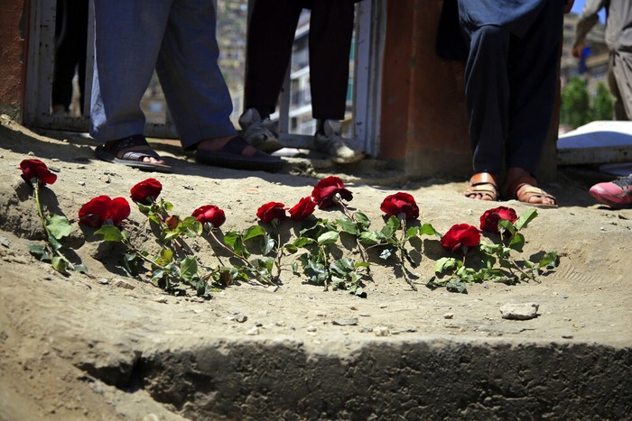 People puts flowers outside a school after a deadly attack on Saturday, in Kabul, Afghanistan, Sunday, May 9, 2021. The Interior Ministry said Sunday that the death toll in the horrific bombing at the entrance to the girls school in the Afghan capital has soared to some 50 people, many of them pupils between 11 and 15 years old, and the number of wounded in Saturdays attack has also climbed to more than 100. (AP Photo/Mariam Zuhaib)