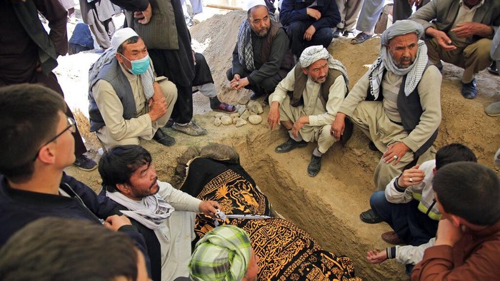 Bom Meledak di Dekat Sekolah Afghanistan, 50 Orang Tewas Afghan men bury a victim of deadly bombings on Saturday near a school, at a cemetary west of Kabul, Afghanistan, Sunday, May 9, 2021. The Interior Ministry said Sunday the death toll in the horrific bombing at the entrance to a girls' school in the Afghan capital has soared to some 50 people, many of them pupils between 11 and 15 years old, and the number of wounded in Saturday's attack has also climbed to more than 100. (AP Photo/Mariam Zuhaib)