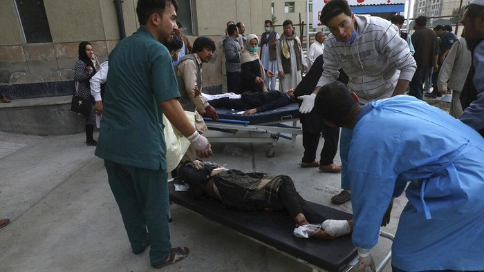 Bom Meledak di Dekat Sekolah Afghanistan, 50 Orang Tewas Afghan men try to identify the dead bodies at a hospital after a bomb explosion near a school west of Kabul, Afghanistan, Saturday, May 8, 2021. A bomb exploded near a school in west Kabul on Saturday, killing several people, many them young students, an Afghan government spokesmen said. (AP Photo/Rahmat Gul)