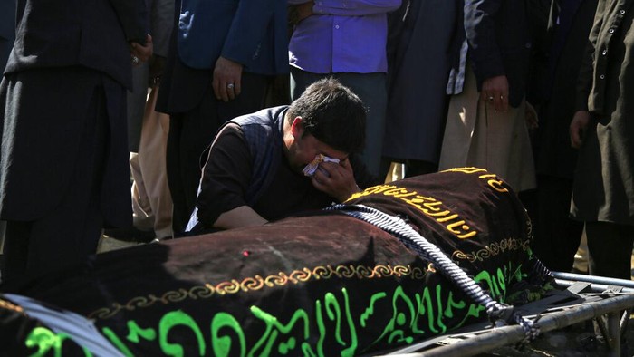 Bom Meledak di Dekat Sekolah Afghanistan, 50 Orang Tewas A man cries over the body of a victim of deadly bombings on Saturday near a school, at a cemetery west of Kabul, Afghanistan, Sunday, May 9, 2021. The Interior Ministry said Sunday the death toll in the horrific bombing at the entrance to a girls' school in the Afghan capital has soared to some 50 people, many of them pupils between 11 and 15 years old, and the number of wounded in Saturday's attack has also climbed to more than 100. (AP Photo/Mariam Zuhaib)