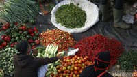 Pedagang cabai sedang melayani pembeli di pasar tradisional.