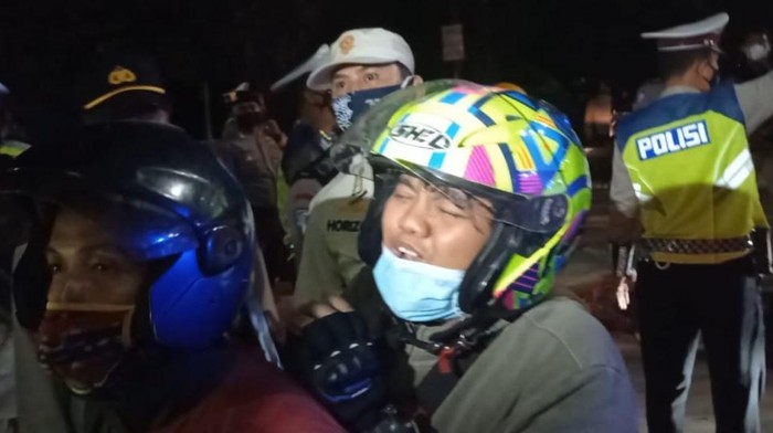 Seorang penumpang motor menangis saat disetop polisi di Kedungwaringin, meminta diberi jalan pulang karena keluarganya meninggal, Senin (10/5/2021).