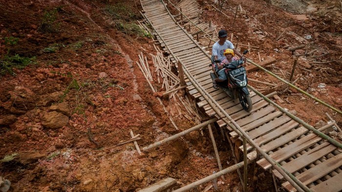 Warga melintasi jembatan yang dibangun secara swadaya di Desa Citorek Kidul, Lebak, Banten, Senin (10/5/2021). Warga setempat mengeluhkan jalan penghubung antardesa Citorek Kidul dan Citorek Tengah tersebut sering terjadi longsor ketika hujan deras dan belum dibangun sehingga mengganggu aktivitas warga. ANTARA FOTO/Muhammad Bagus Khoirunas/aww.