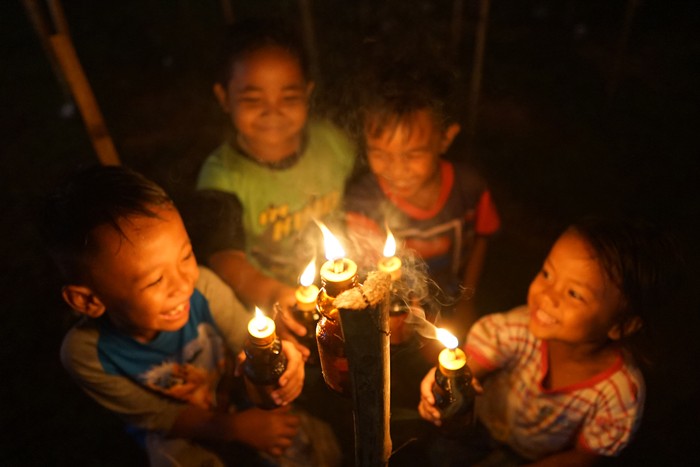 Foto udara deretan lampu minyak pada perayaan tradisi Tumbilotohe atau malam pasang lampu di Telaga, Kabupaten Gorontalo, Gorontalo, Minggu (9/5/2021). Perayaan malam pasang lampu tersebut dilakukan tiga hari jelang Idul Fitri dan menyambut malam Lailatul Qadar dengan menyalakan lampu minyak di halaman rumah, masjid dan lapangan. ANTARA FOTO/Adiwinata Solihin/hp.