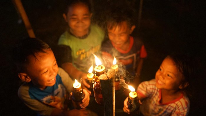Foto udara deretan lampu minyak pada perayaan tradisi Tumbilotohe atau malam pasang lampu di Telaga, Kabupaten Gorontalo, Gorontalo, Minggu (9/5/2021). Perayaan malam pasang lampu tersebut dilakukan tiga hari jelang Idul Fitri dan menyambut malam Lailatul Qadar dengan menyalakan lampu minyak di halaman rumah, masjid dan lapangan. ANTARA FOTO/Adiwinata Solihin/hp.