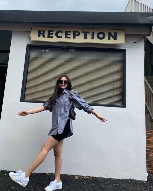 Tak harus terkesan sporty. Biker sports hitam dapat pula dipadukan dengan kemeja oversized seperti Jennie BLACKPINK.  Kaki dapat terlihat lebih jenjang saat mengenakan sneakers. Foto: dok. Instagram jennierubyjane