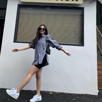 Tak harus terkesan sporty. Biker sports hitam dapat pula dipadukan dengan kemeja oversized seperti Jennie BLACKPINK.  Kaki dapat terlihat lebih jenjang saat mengenakan sneakers. Foto: dok. Instagram jennierubyjane