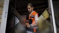 Seorang warga Israel memeriksa kerusakan yang diakibatkan serangan roket dari Gaza. AP Photo/Tsafrir Abayov.