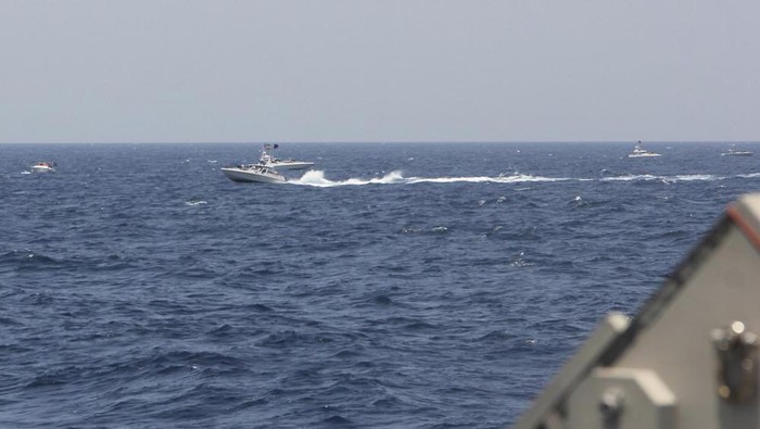 In this image provided by the U.S. Navy, an Iranian Islamic Revolutionary Guard Corps Navy (IRGCN) fast in-shore attack craft (FIAC), a type of speedboat armed with machine guns, speeds near U.S. naval vessels transiting the Strait of Hormuz, Monday, May 10, 2021. U.S. officials say a group of 13 armed speedboats of Iran’s Revolutionary Guard made “unsafe and unprofessional” high-speed maneuvers toward U.S. Navy vessels in the Strait of Hormuz on Monday. A U.S. Coast Guard cutter fired warning shots when two of the Iranian boats came dangerously close. (U.S. Navy via AP)