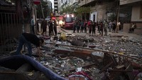 Seorang warga Palestina mencari barang-barang yang dapat diselamatkan di antara puing-puing bangunan yang porak poranda terdampak serangan udara dari Israel di kawasan Kota Gaza, Selasa (11/5/2021). AP Photo/Khalil Hamra.  