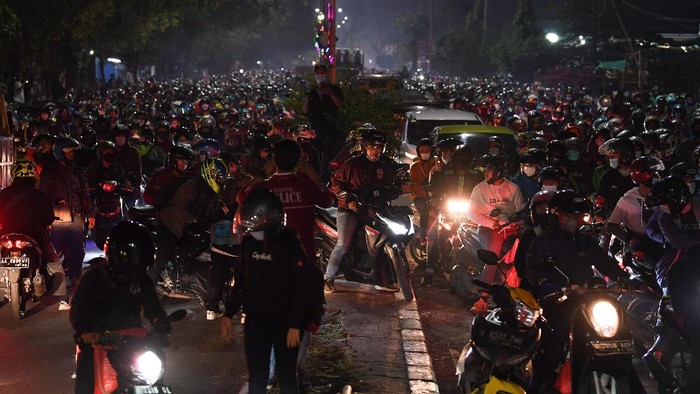 Seorang pemudik yang menggunakan sepeda motor menyiapkan surat jalan saat terjebak kemacetan di posko penyekatan mudik Kedungwaringin, Kabupaten Bekasi, Jawa Barat, Senin (10/5/2021). Polda Metro Jaya menambah jumlah petugas guna mengecek ribuan pemudik yang melintasi pos penyekatan perbatasan Bekasi -Karawang, Jawa Barat. ANTARA FOTO/Wahyu Putro A/aww.
