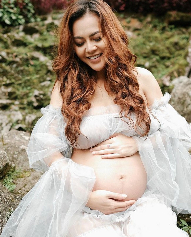 Sambil memegang perut hamilnya, Ratu Nabila berpose tersenyum seolah mencoba tegar di tengah kesedihan hatinya. Foto: Dok.Instagram