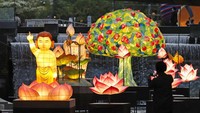 Pengunjung berjalan di dekat lentera yang ditampilkan untuk perayaan ulang tahun Buddha di ruang publik Seoul, Korea Selatan, Senin (10/5/2021).  